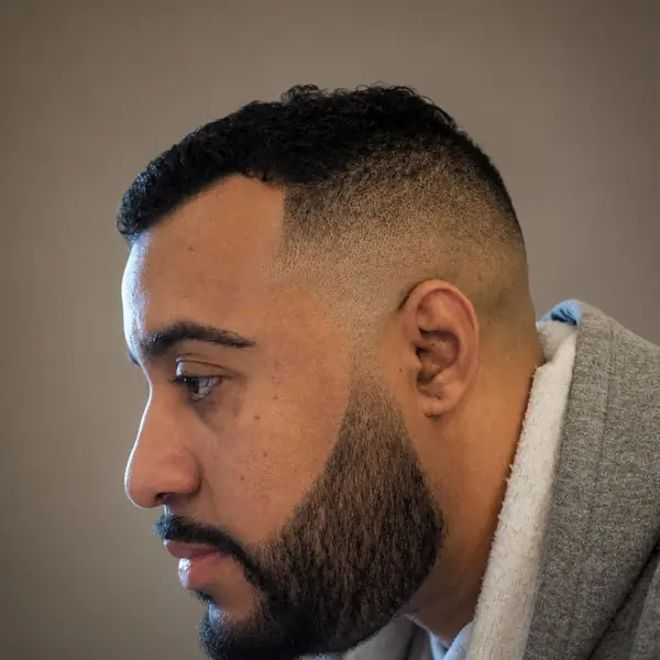 Client in profile with a clean taper and full beard