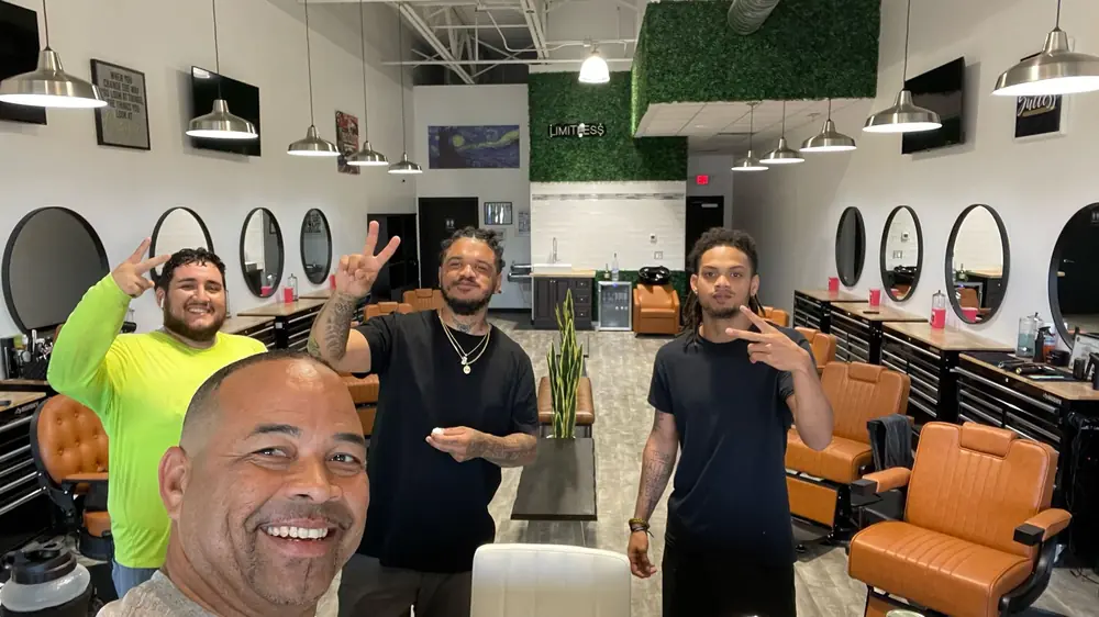 The Limitless barbers in the shop, in front of the ring-lit stations